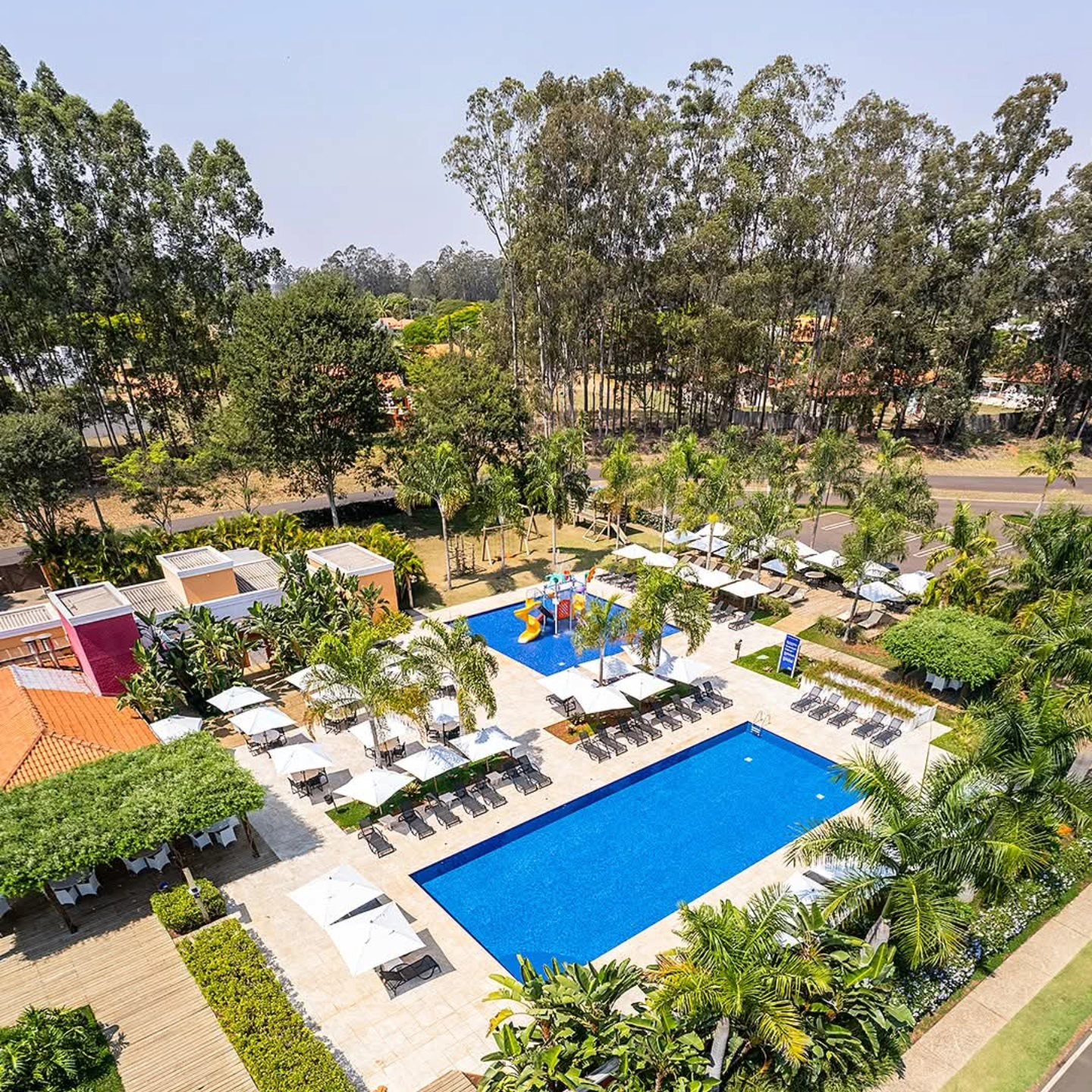 Clube contemporâneo inserido na verdejante vegetação do residencial